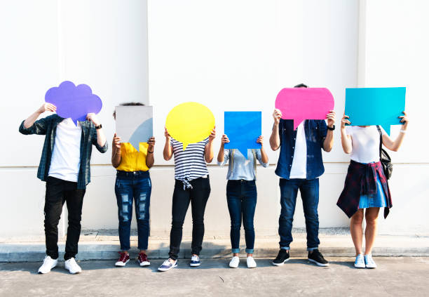 Young adult friends holding up copy space placard thought bubbles