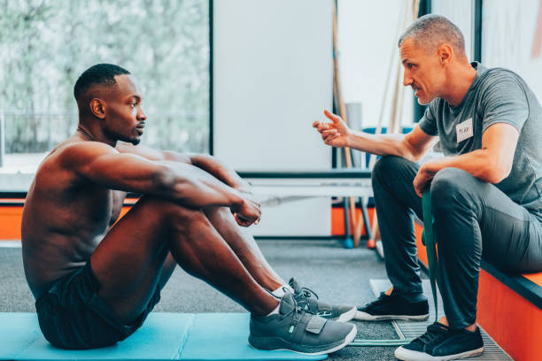 Personal trainer and athlete discussing how to stay motivated in the gym