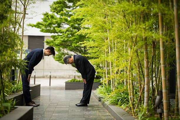 Japanese businessmen bowing in traditional Japanese customs used when greeting colleagues and formalizing deals