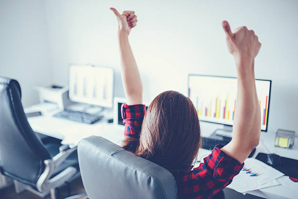 This conceptual image depicts a professional reviewing financial data at a modern workspace. Salary growth charts showing 300-400万円 are displayed, alongside a bookshelf filled with career-related books and certificates. The image emphasizes ambition, skill development, and financial success.